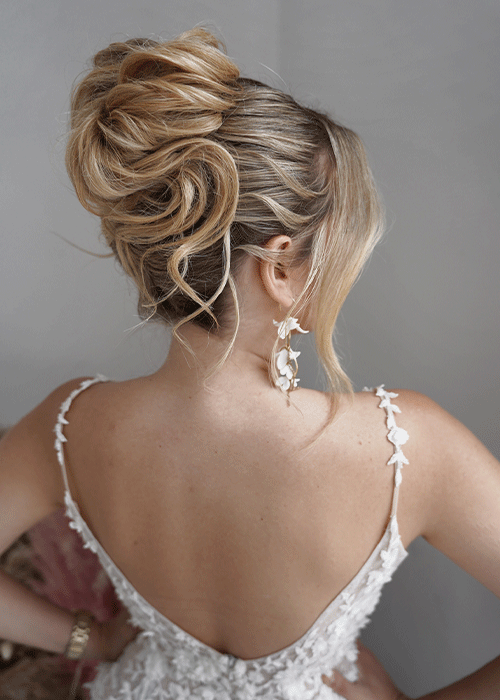 Rückansicht einer kunstvollen Hochsteckfrisur mit lockeren Strähnen für Paket 3 Hairstylist Ausbildung