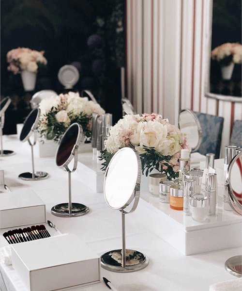 Tisch mit Spiegeln, Blumen und Beauty-Produkten für eine Make-up Party dekoriert